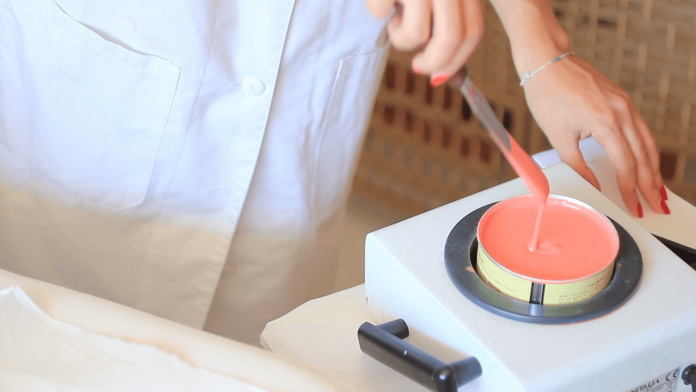 esthetician-wiping-wax-off-applicator